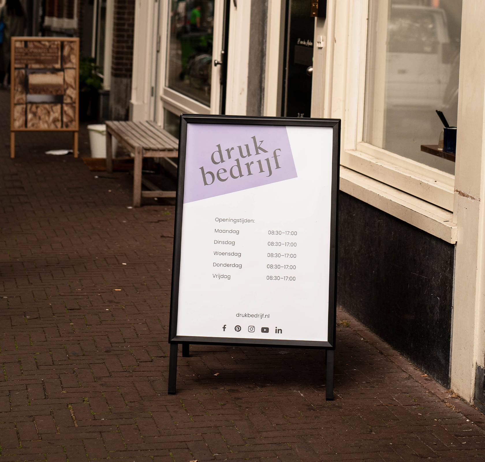 klapbord met stoepbord poster openingstijden staat voor Amsterdamse winkel