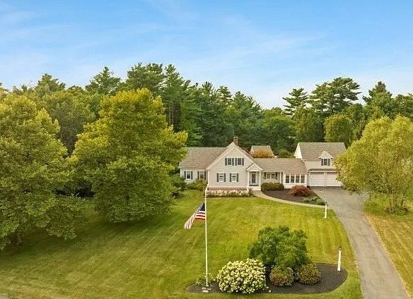 Aerial view of a two-story residential home with attached garage in Lakeville, surrounded by mature landscaping and driveway.