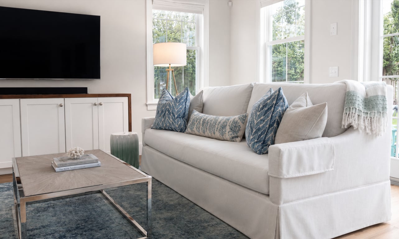 Living room with new white cabinetry, large windows, and finished interior in a home remodel.