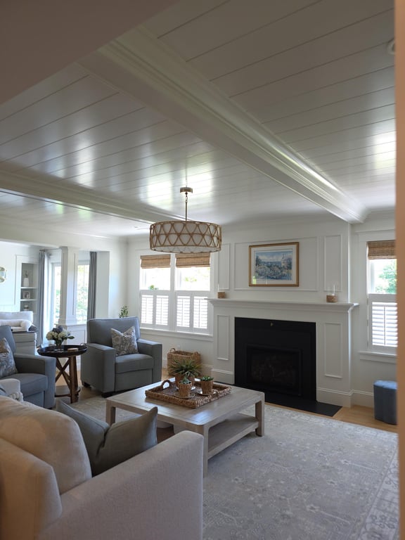 Renovated living room in Marion with white shiplap ceiling, fireplace with built-in surround, pendant lighting, and upholstered seating.
