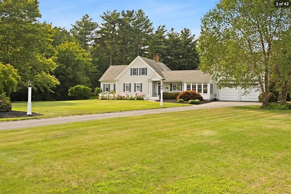White farmhouse-style home with attached garage situated on a landscaped property in Lakeville, showing exterior renovation and addition work.