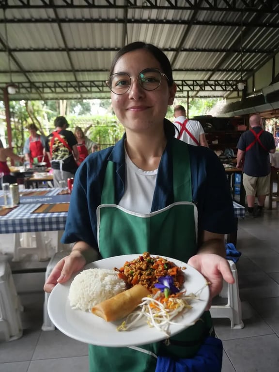 Holding a plate of food I cooked at a Thai cooking class