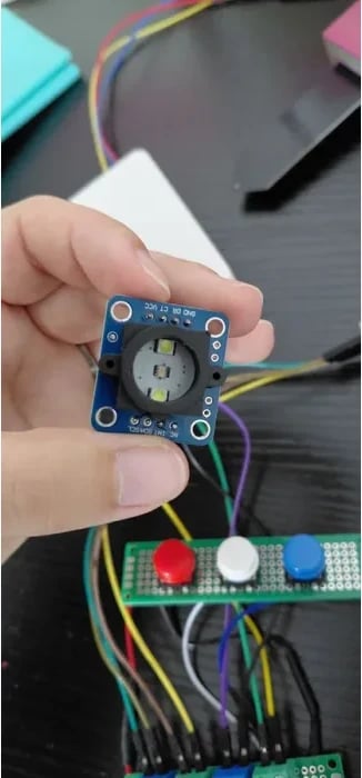 GY-33 colour sensor module and illuminated sensing head held above the wired perfboards