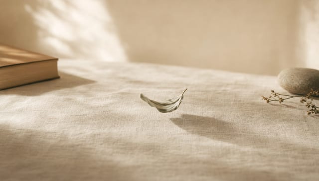 A single leaf appearing unsettled and agitated on cream linen