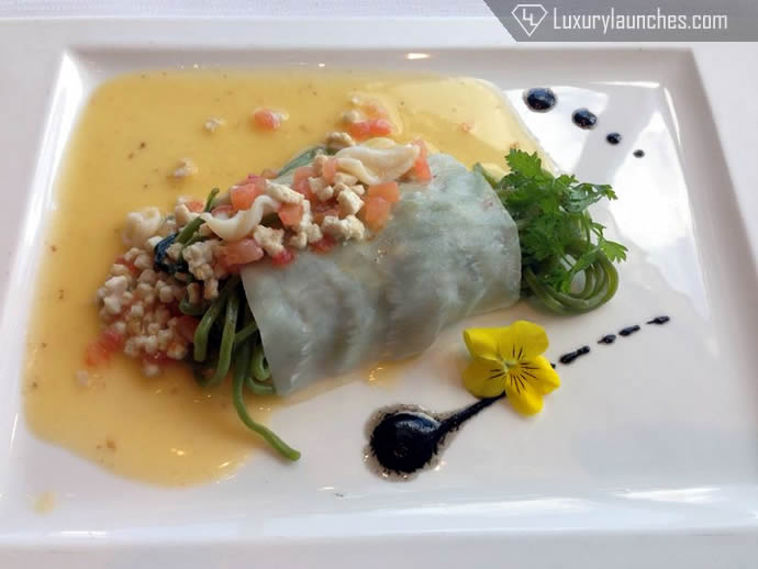 Spaghetti “alla chitarra” flavored with basil chlorophyll and wrapped in swordfish paper with baby squid stew and black olive oil
