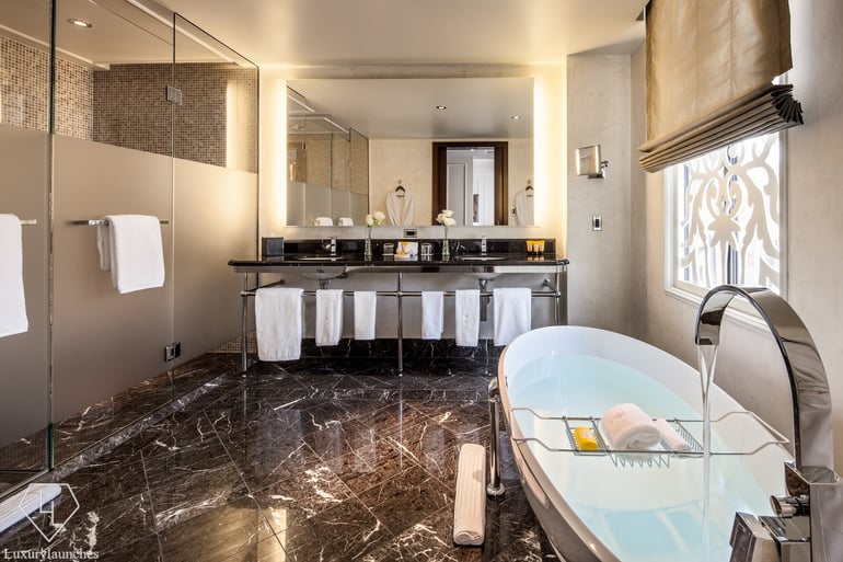 The expansive and luxurious bathroom done up in marble and tones of black and gold will make you never want to leave.