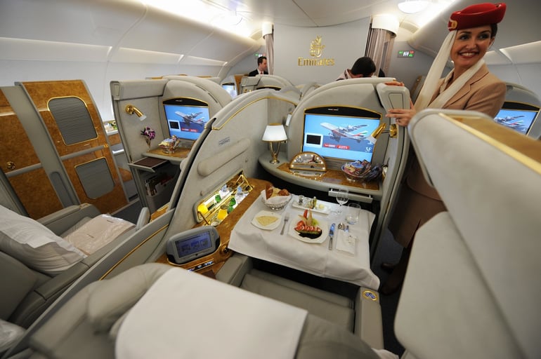 A flight attendant stands next to first