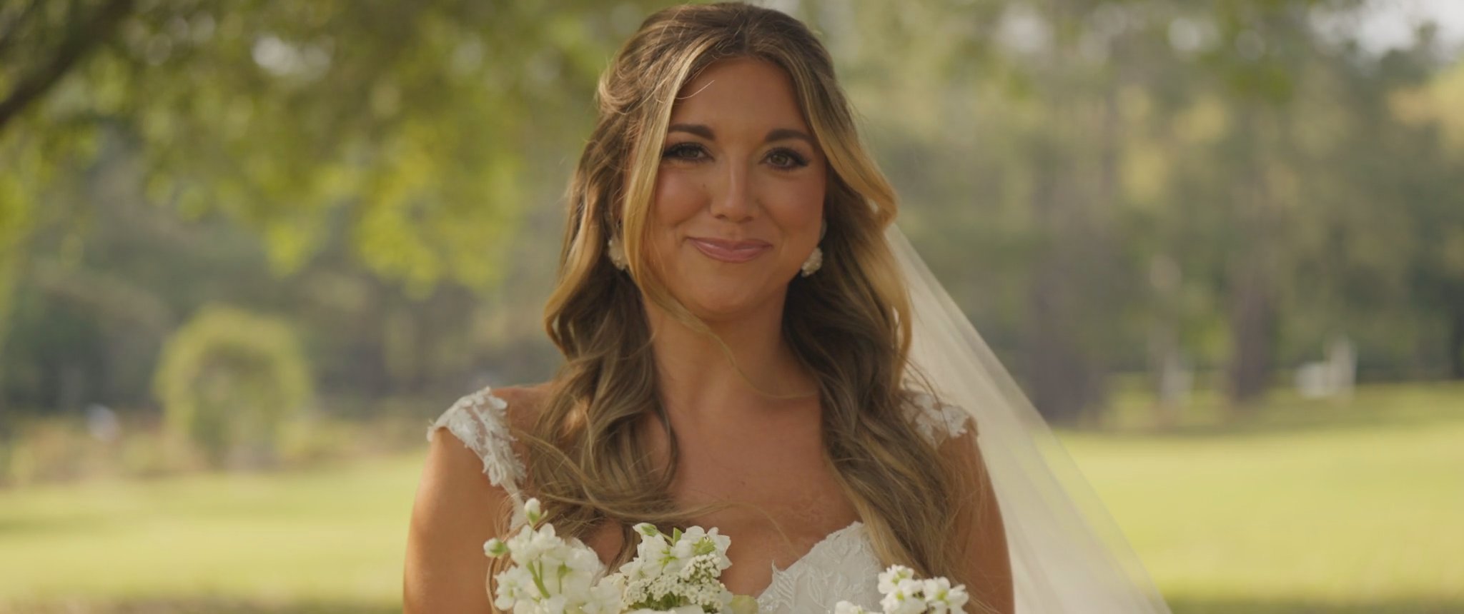 Montana with her bouquet in the afternoon light. Still from their Midsummer Productions wedding film.