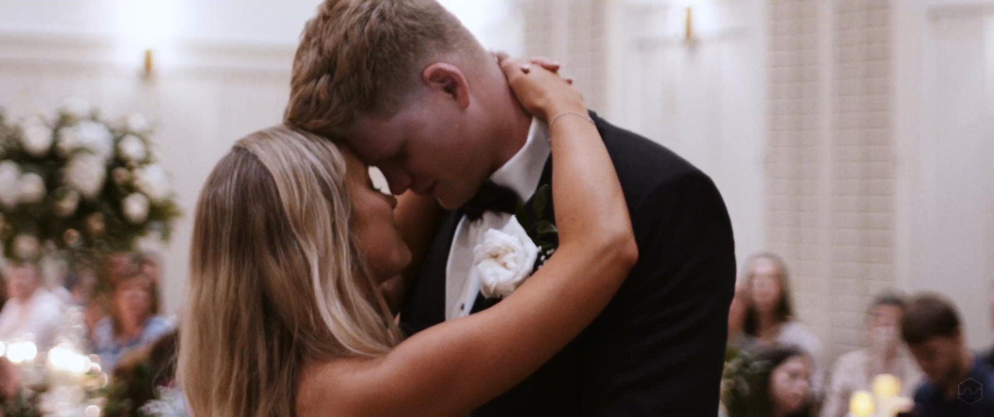Madalyn and Caleb lean close during their first dance. Still from their Midsummer Productions wedding film.