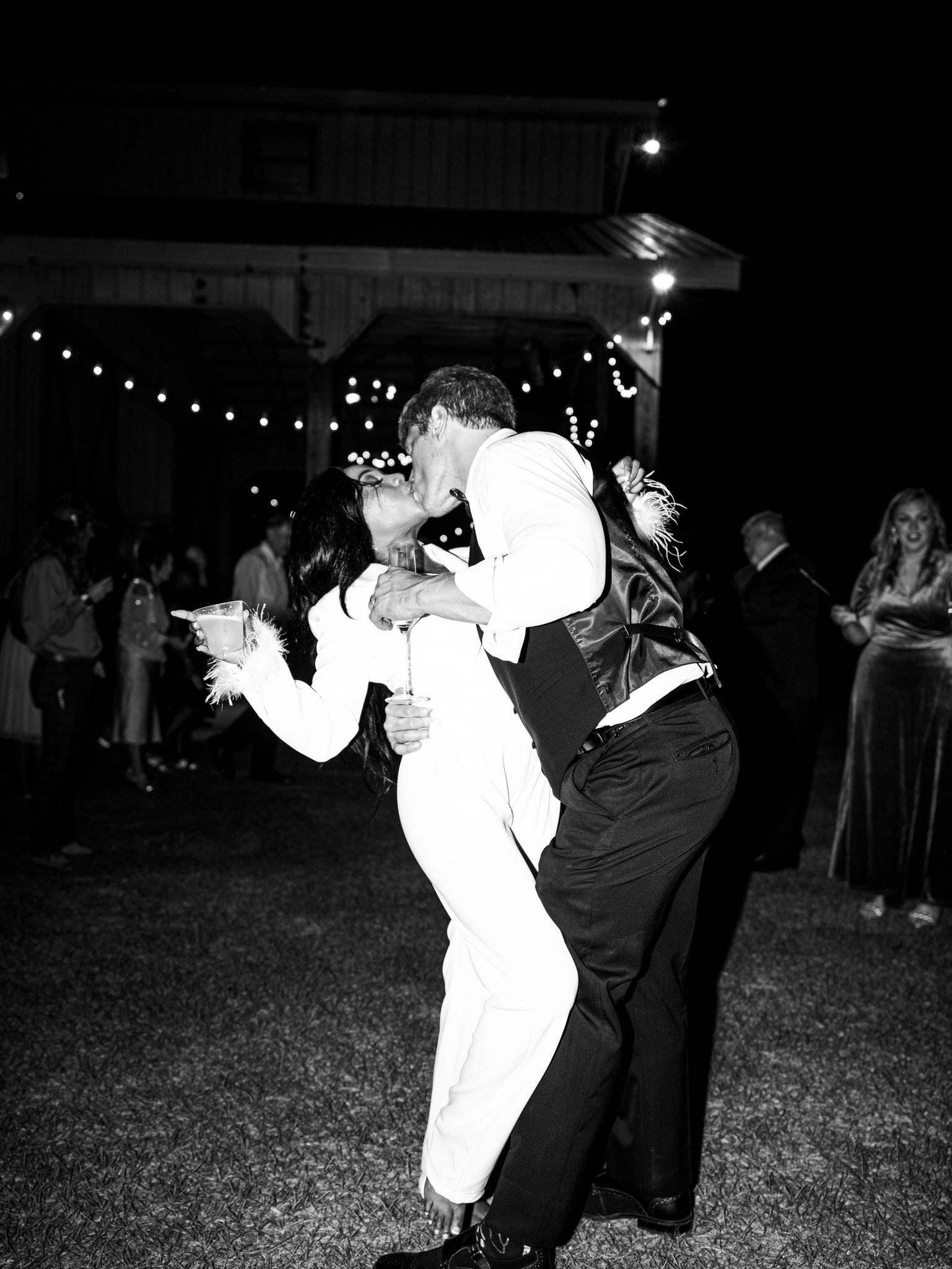 In black and white, Jason dips Ashley back for a kiss on the lawn at night.