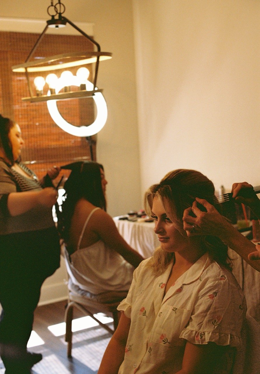 Women having their hair styled on Raley and Drew’s wedding morning at Dalrymple Farms, photographed on film.