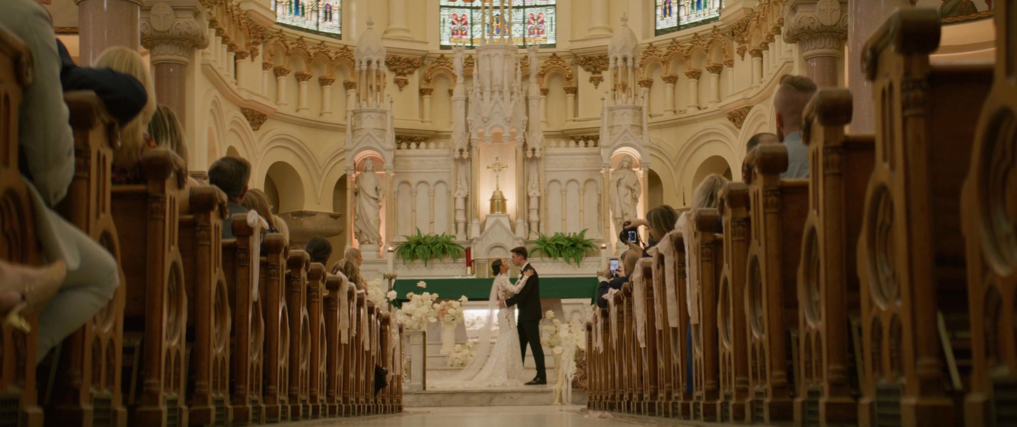 A wide view of Ally and Jake’s ceremony at Sacred Heart. Still from their Midsummer Productions wedding film.
