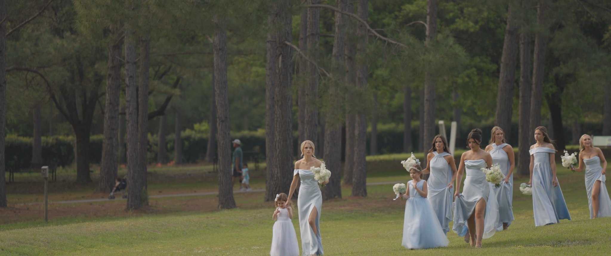 Montana and her bridesmaids walking together outside. Still from their Midsummer Productions wedding film.