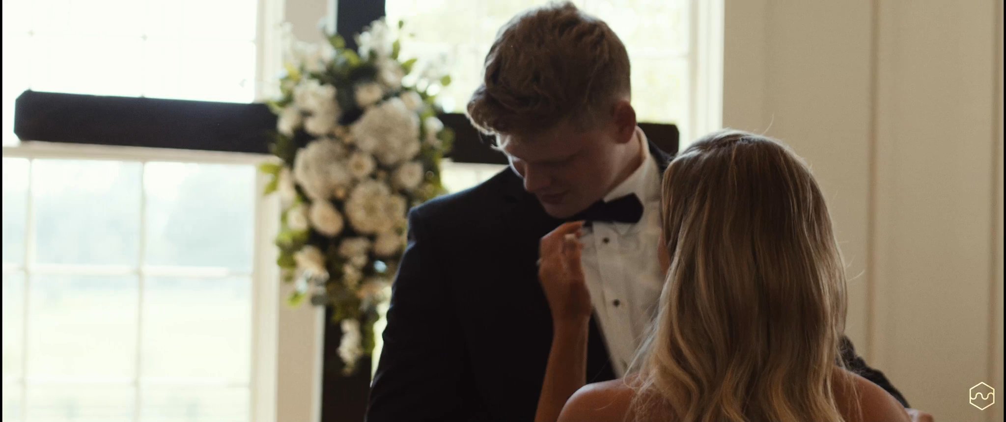 Madalyn and Caleb stand together during their first look. Still from their Midsummer Productions wedding film.
