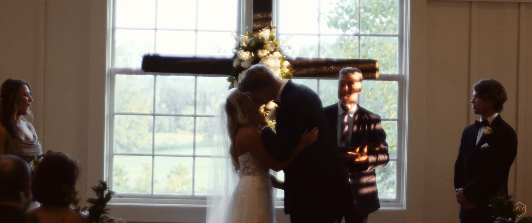 Madalyn and Caleb share their first kiss during the wedding ceremony. Still from their Midsummer Productions wedding film.