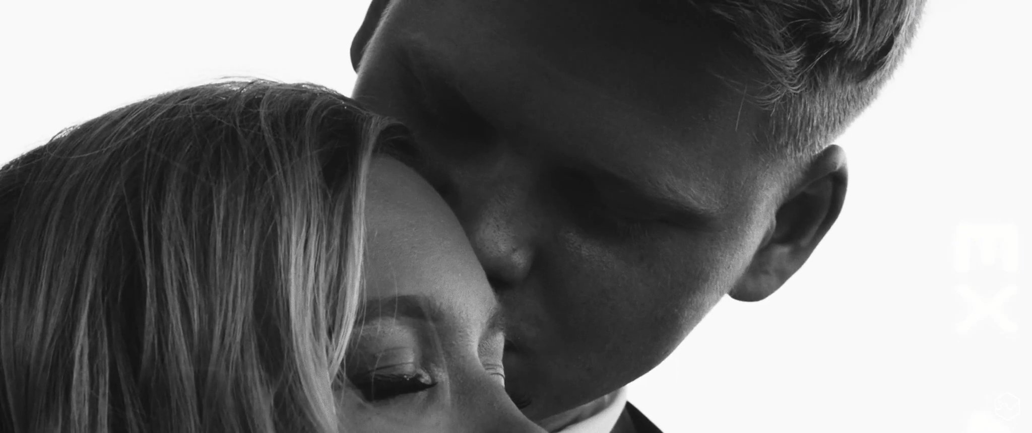 A black-and-white close-up of Madalyn and Caleb together. Still from their Midsummer Productions wedding film.