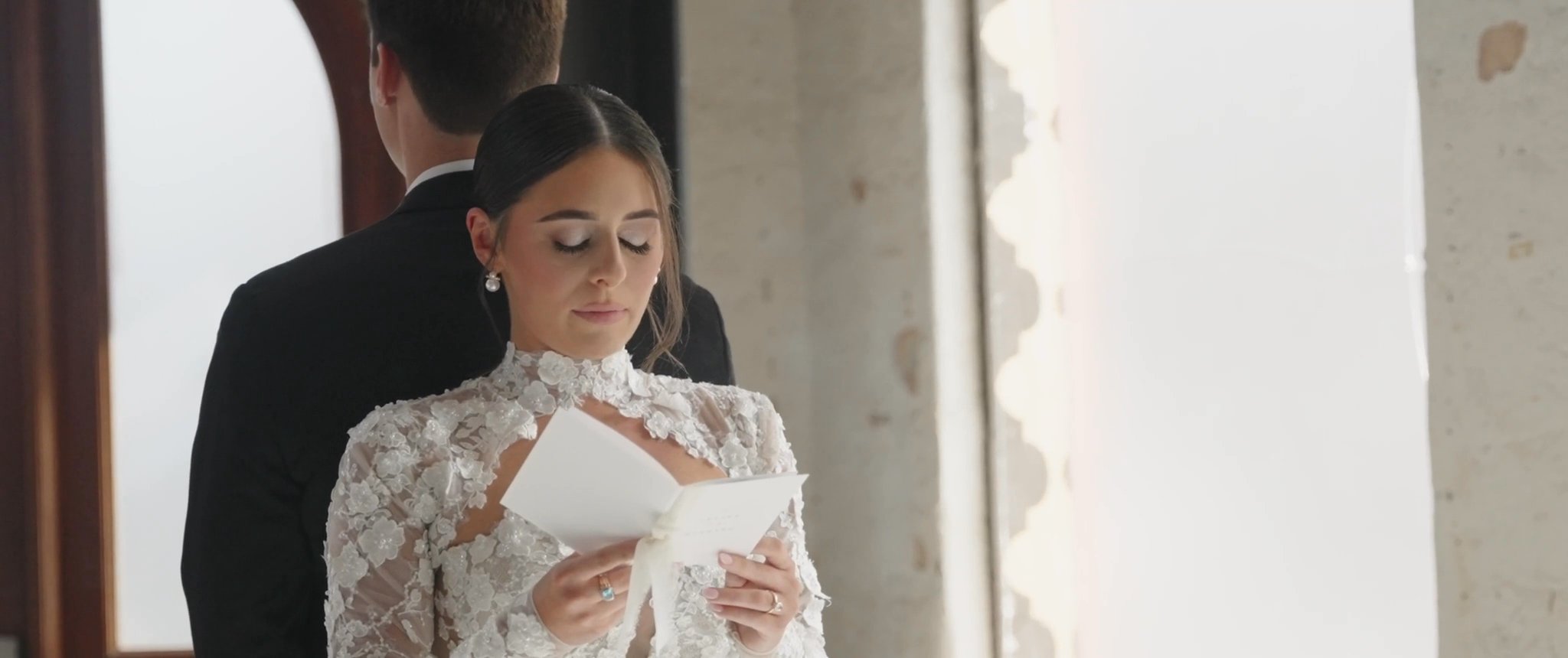 Ally reads her letter while standing back to back with Jake. Still from their Midsummer Productions wedding film.