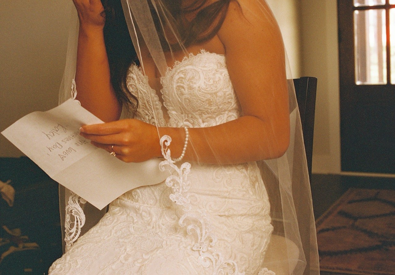 A close view of Raley’s lace dress, veil, pearl bracelet and handwritten letter at Dalrymple Farms, photographed on film.