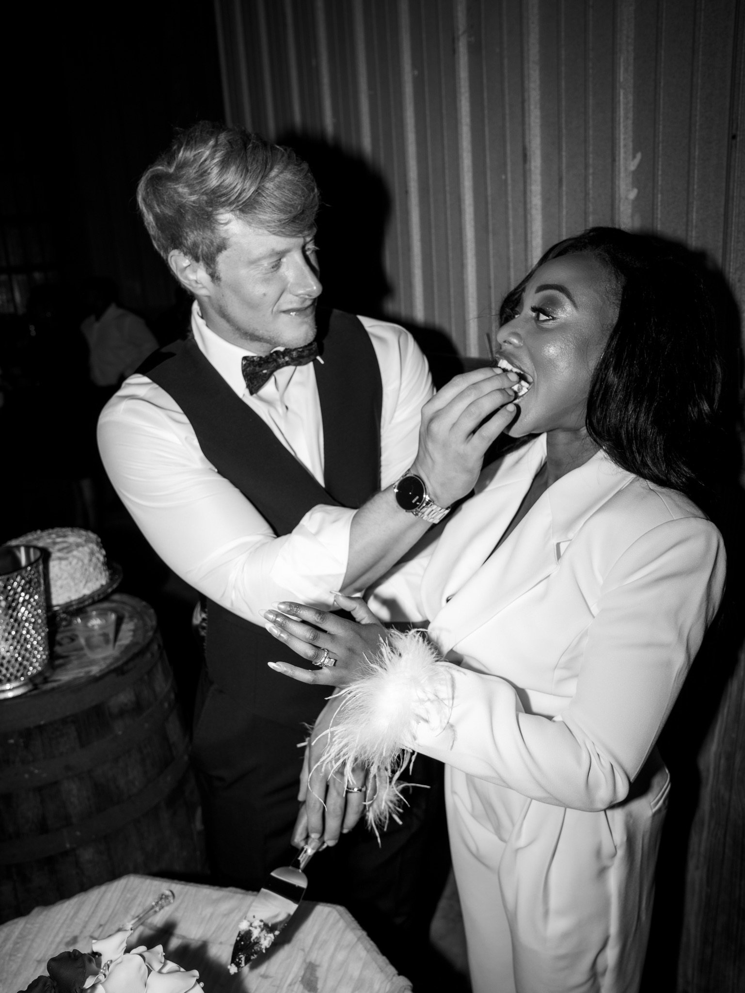 In black and white, Jason feeds Ashley a bite of cake.