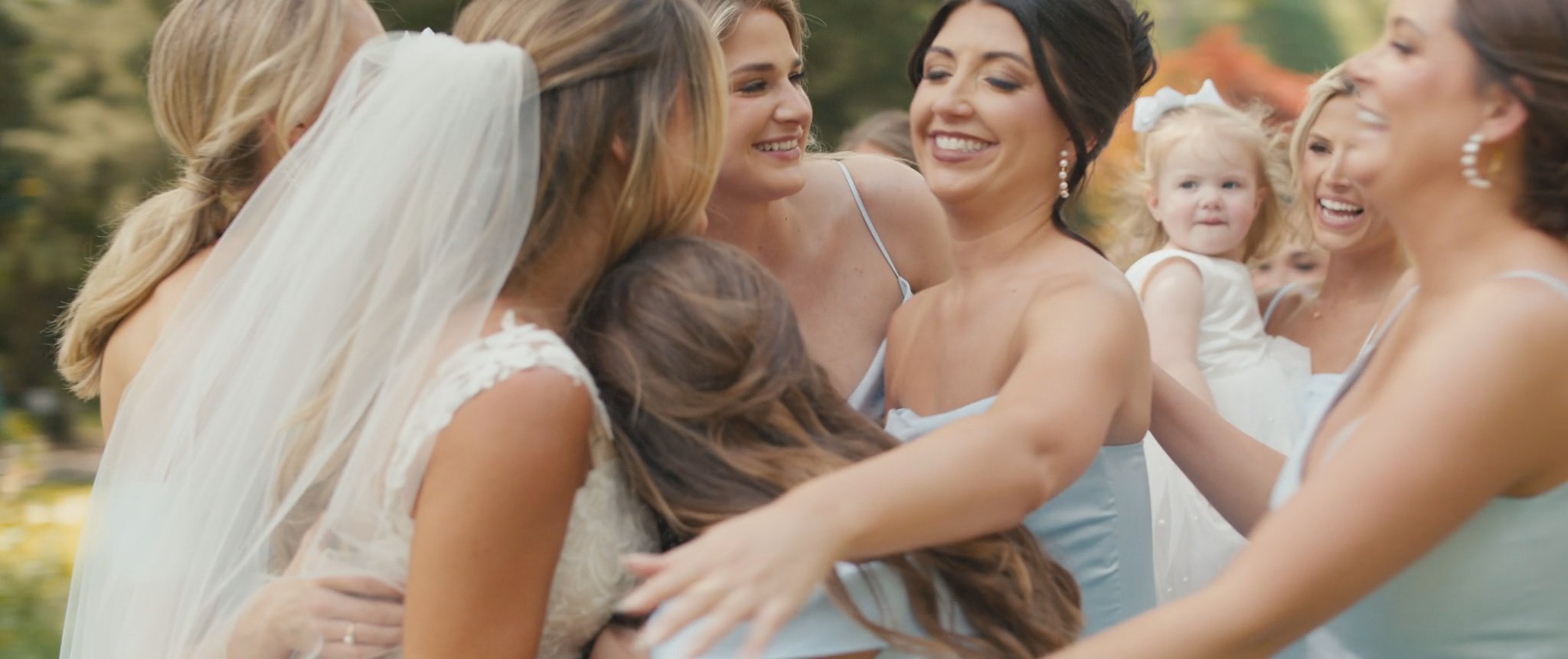 Montana hugging a bridesmaid after the dress reveal. Still from their Midsummer Productions wedding film.
