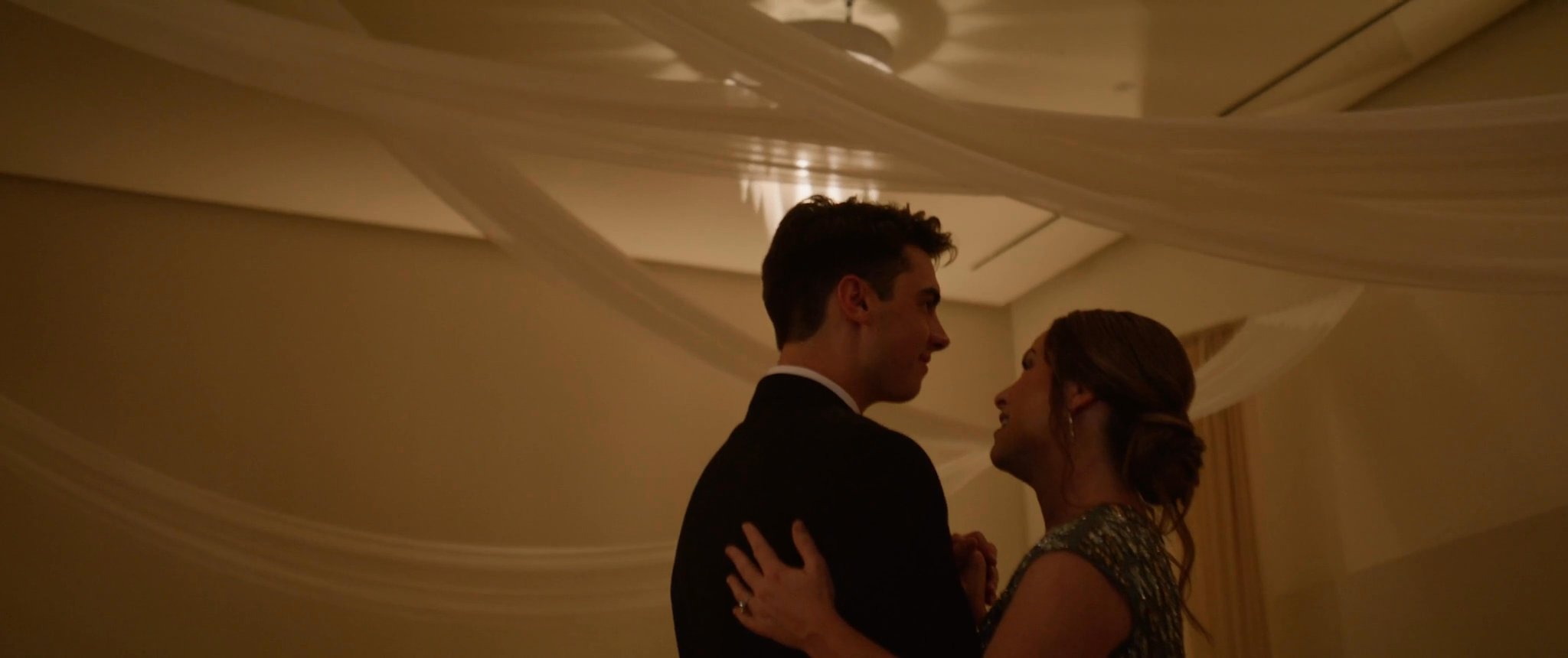 Ally and Jake dancing together under the reception draping. Still from their Midsummer Productions wedding film.
