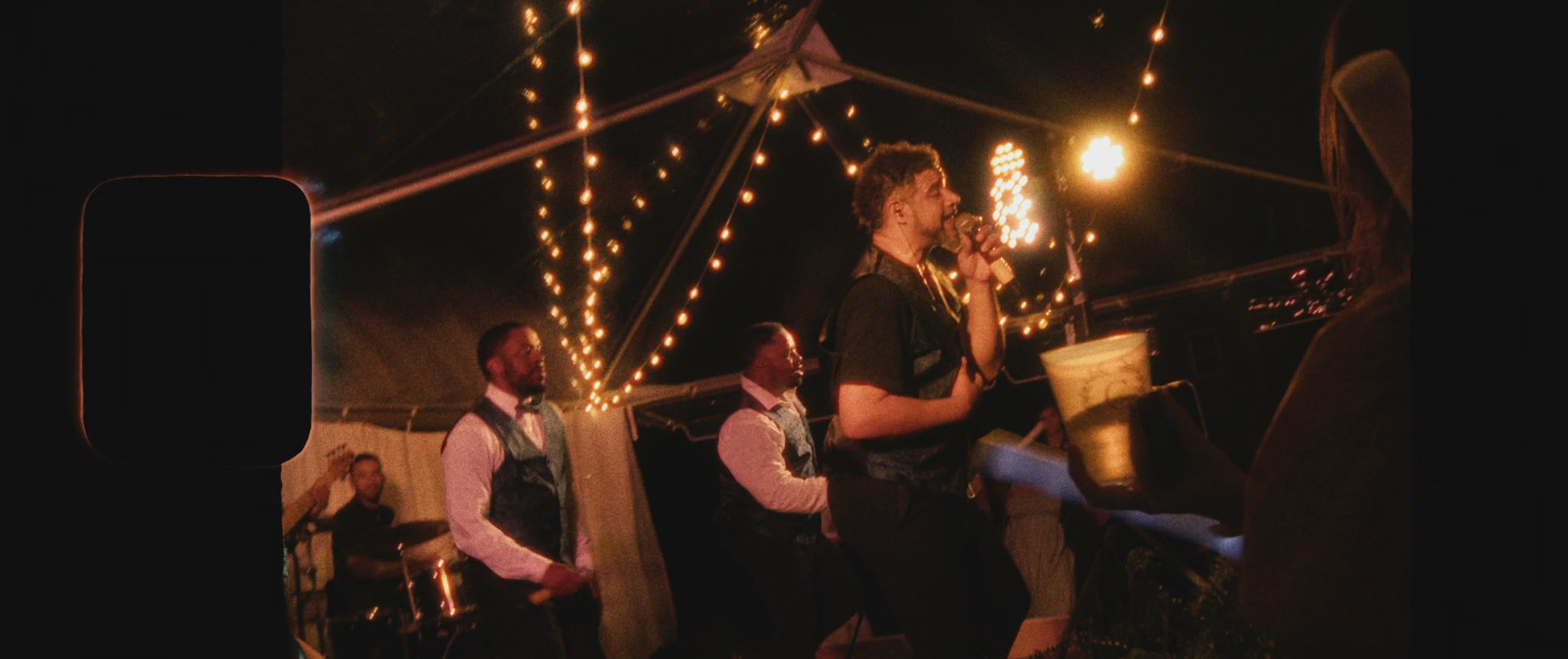 Montana and Cam walking together through the sparkler send-off. Still from their Midsummer Productions wedding film.