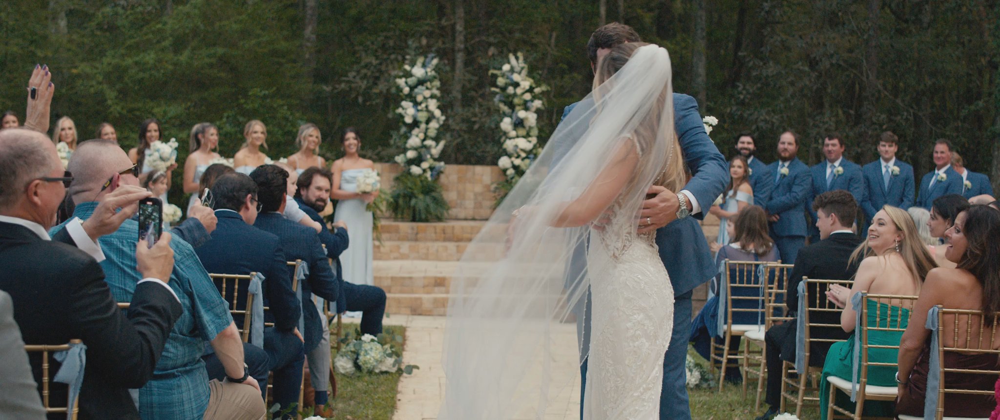 Montana and Cam sharing a kiss at their ceremony. Still from their Midsummer Productions wedding film.