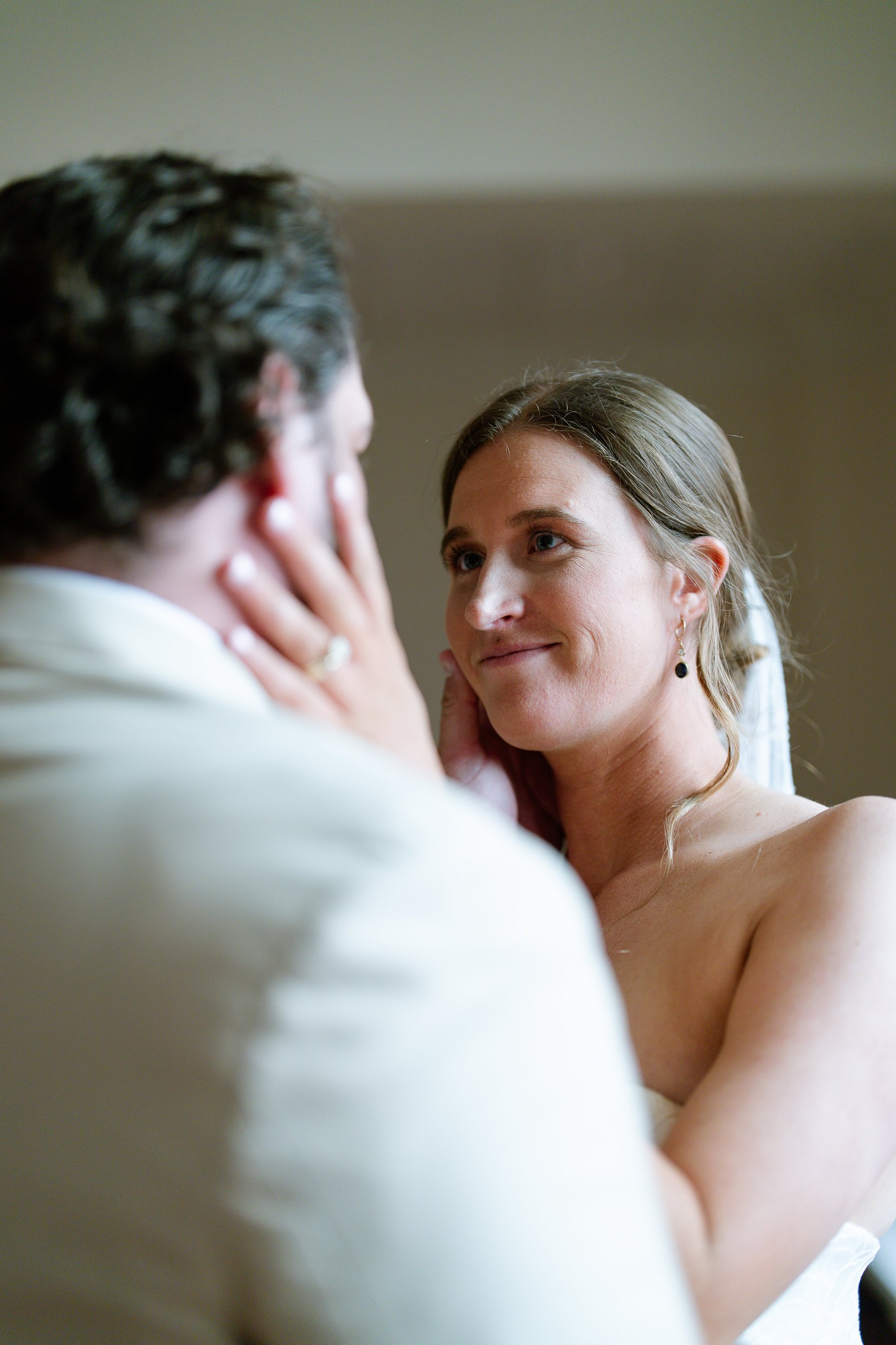 Elizabeth smiles up at Dustin as a hand rests against her cheek.