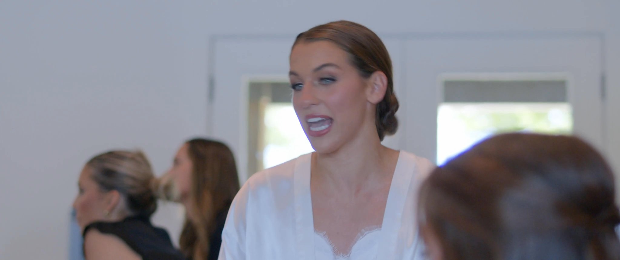 Julianna having her hair styled during the wedding morning. Still from their Midsummer Productions wedding film.