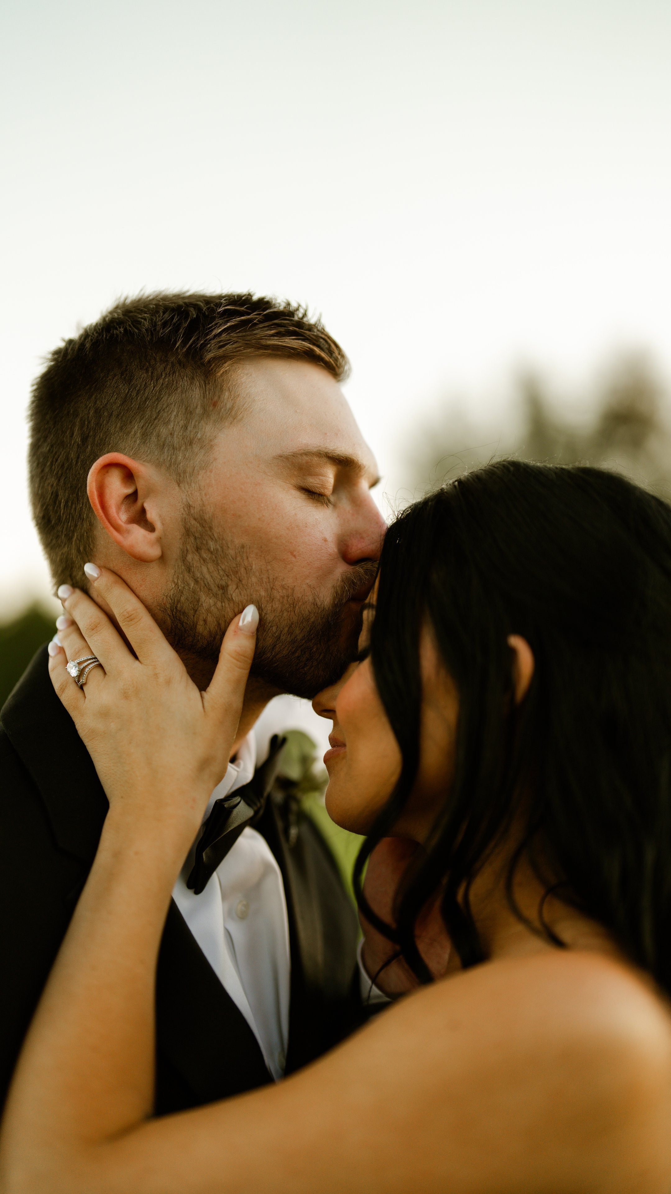 Corey kissing Kenadee on the forehead while she rests her hand on his face.