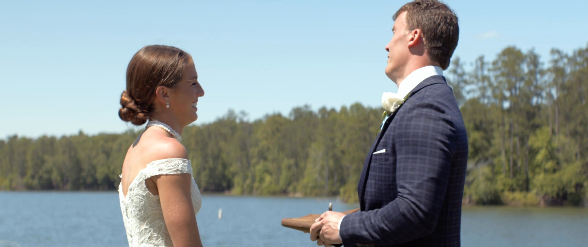 Julianna and Jake talking together by the water. Still from their Midsummer Productions wedding film.