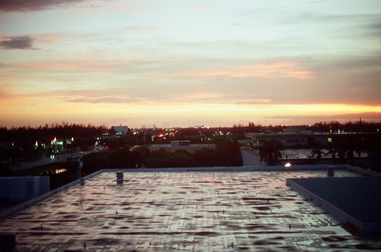 Sunset over rooftops and palm trees during Raley’s Miami trip, photographed on film.