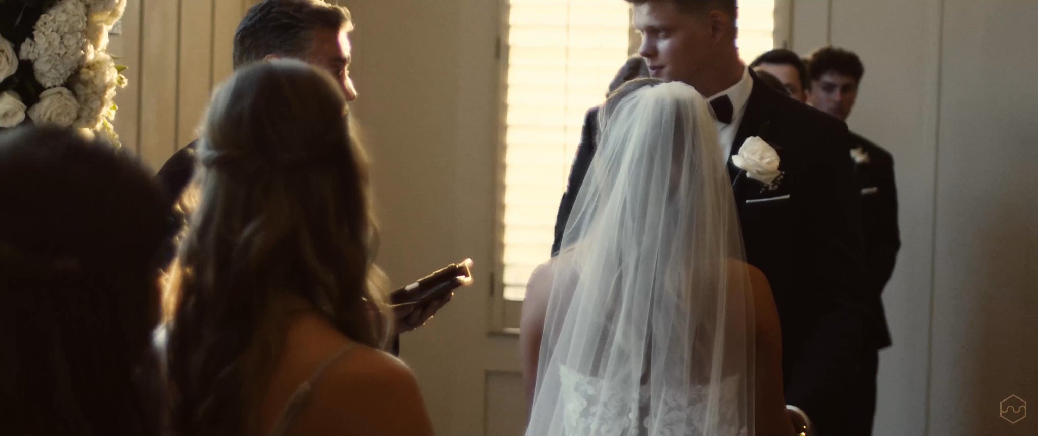 Madalyn and Caleb face each other during their wedding ceremony. Still from their Midsummer Productions wedding film.