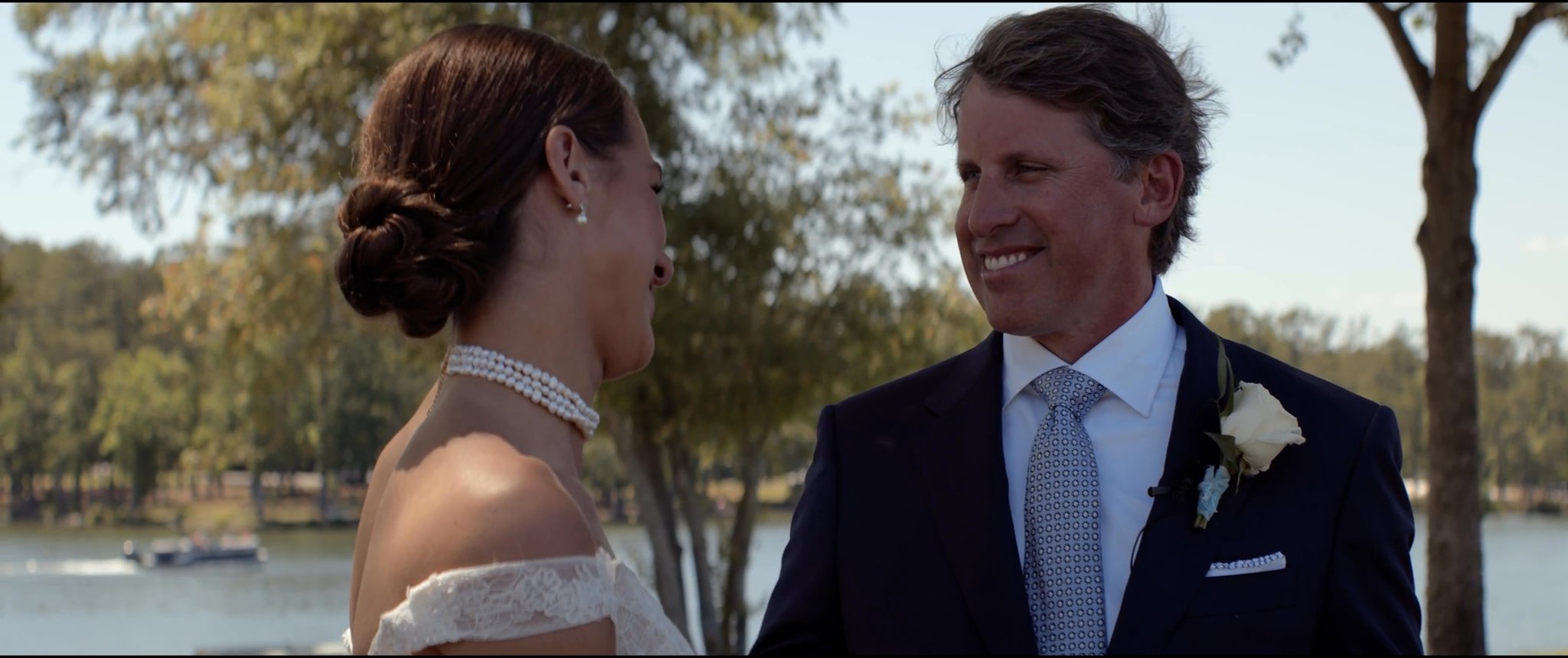 Julianna and her dad smiling together after their first look. Still from their Midsummer Productions wedding film.