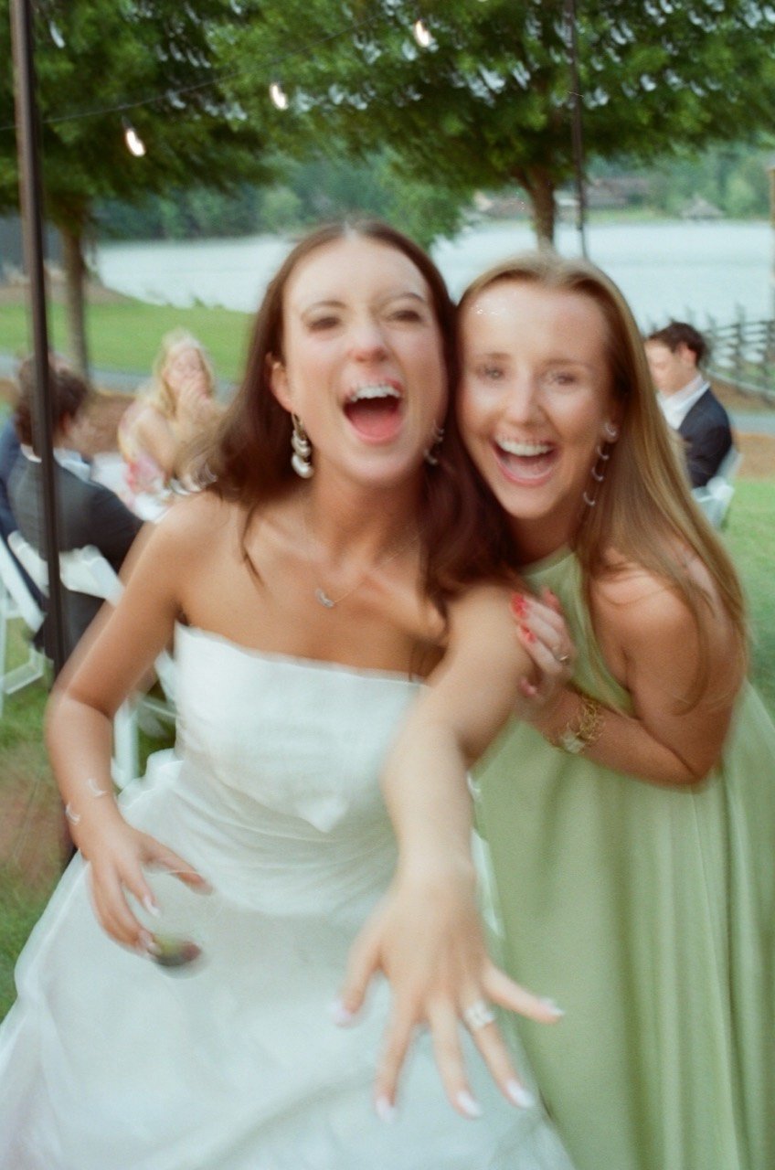 Brooklyn laughs with a friend beside the lake at New Water Farms, photographed on film.