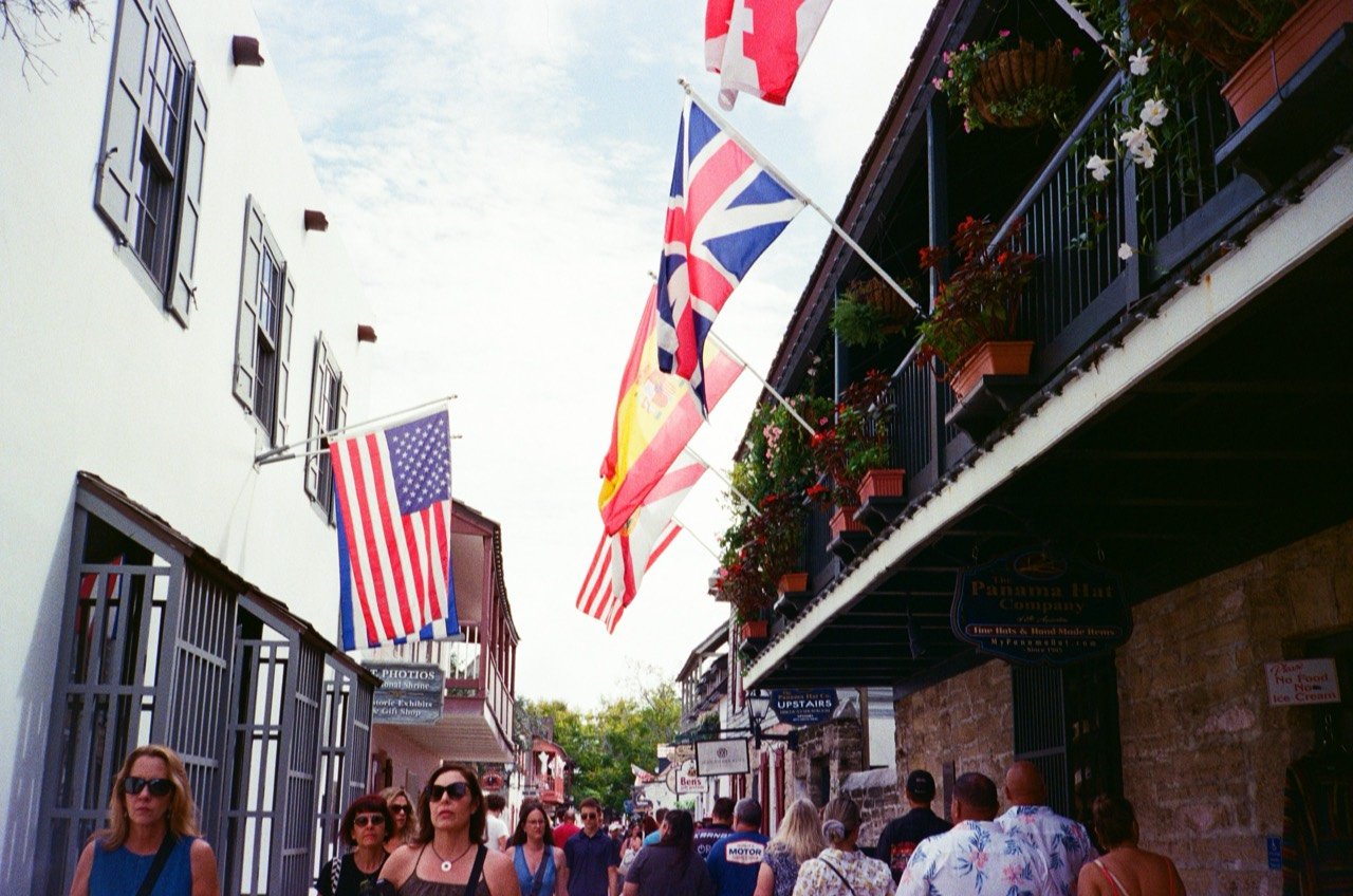 Flags above a busy pedestrian street in St. Augustine.