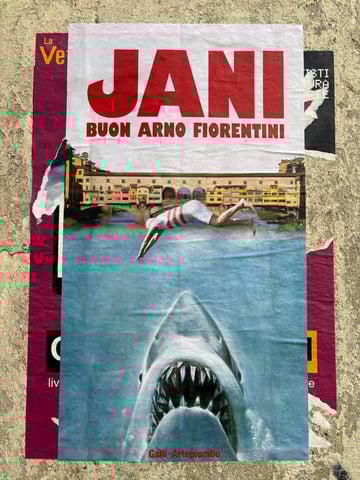 A large vertical wheatpaste poster depicting a surreal scene where a vintage diver leaps into the Arno river in Florence, straight toward an emerging great white shark. The artwork is layered over existing posters on a weathered urban wall, creating a rich texture of street decay.. Subject: A surreal collage featuring the Ponte Vecchio, a diver in a vintage striped swimsuit, and a giant shark.. Style: Surrealist photographic collage with bold typography. Details: The poster features the large red text 'JANI' and 'BUON ARNO FIORENTINI' at the top, and the artist credit 'Galli_Artepiombo' at the bottom.. Shape: rectangular. Setting: Urban environment. Surface: An urban concrete wall used for community notices and street art.. Colors: #C1272D (Deep Red), #5FA4C1 (River Blue), #E7E0D5 (Parchment), #88124C (Magenta Overlay). Composition: Centered vertical composition that guides the eye from the bold text at the top, down the diver's trajectory, to the shark's mouth.. The artwork subverts classical Italian tourism imagery by introducing an element of absurdity and danger into a serene, iconic landscape. The presence of a shark in the Arno river suggests a humorous or critical commentary on the 'hidden dangers' or the overwhelming nature of mass tourism in historical cities like Florence.