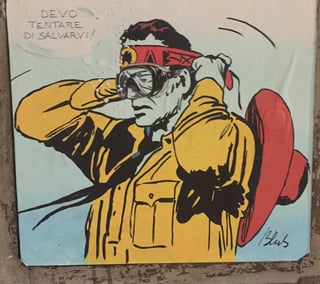 A large wheatpaste artwork depicting a classic comic book cowboy wearing a diving mask. The piece is signed 'Blub' and features a speech bubble with Italian text against a pale blue background.. Subject: A comic book cowboy character, likely Tex Willer, adjusting a scuba mask.. Style: Pop Art / Mid-century comic book illustration style.. Details: Bold black line work with flat colors; the character wears a yellow shirt and red bandana, with a red hat hanging on his back. A speech bubble reads 'DEVO TENTARE DI SALVARVI!' (I must try to save you!).. Shape: Rectangular wheatpaste. Setting: Outdoor urban environment. Surface: A textured urban wall or concrete structure.. Colors: #F3E16B (Mustard Yellow), #D64541 (Crimson Red), #A8DADC (Sky Blue), #1A1A1A (Carbon Black). Composition: Centered portrait orientation with the subject's actions filling the frame.. Part of the 'L'arte sa nuotare' (Art knows how to swim) series by artist Blub. By placing iconic figures like Tex Willer underwater with masks, the artist comments on cultural resilience and the necessity for even traditional heroes to adapt to an changing, potentially drowning world.