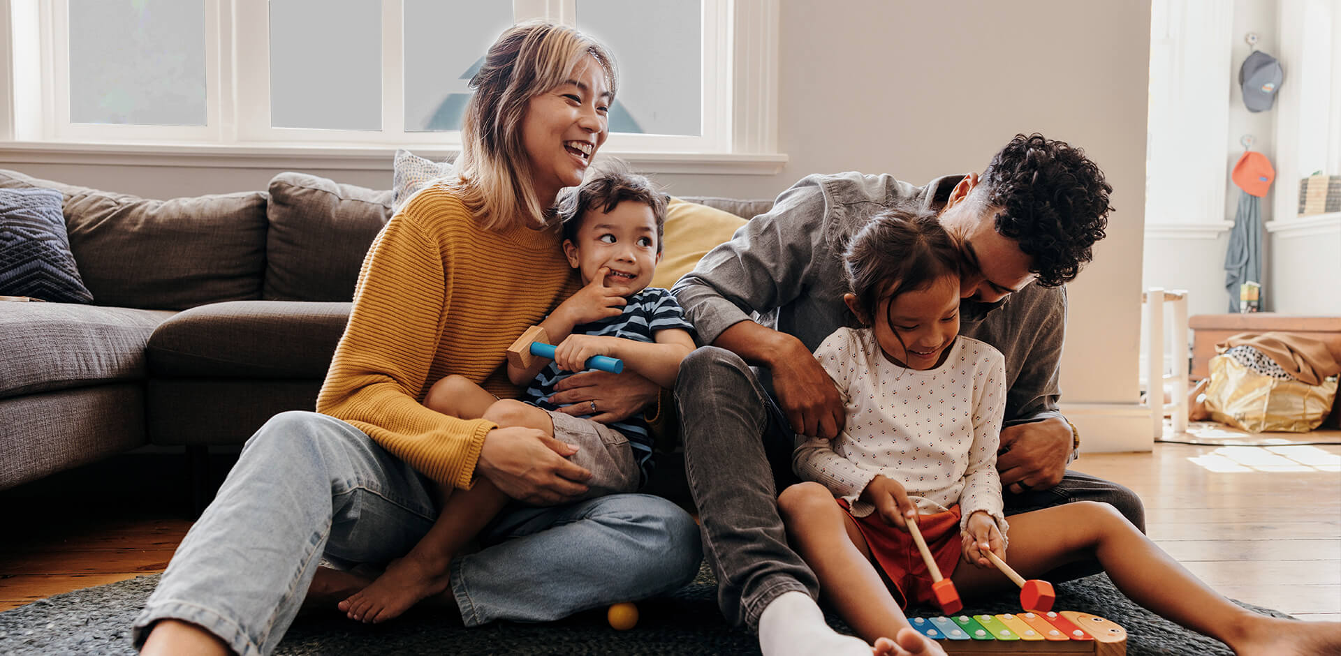 Happy diverse family playing at home with their kids.