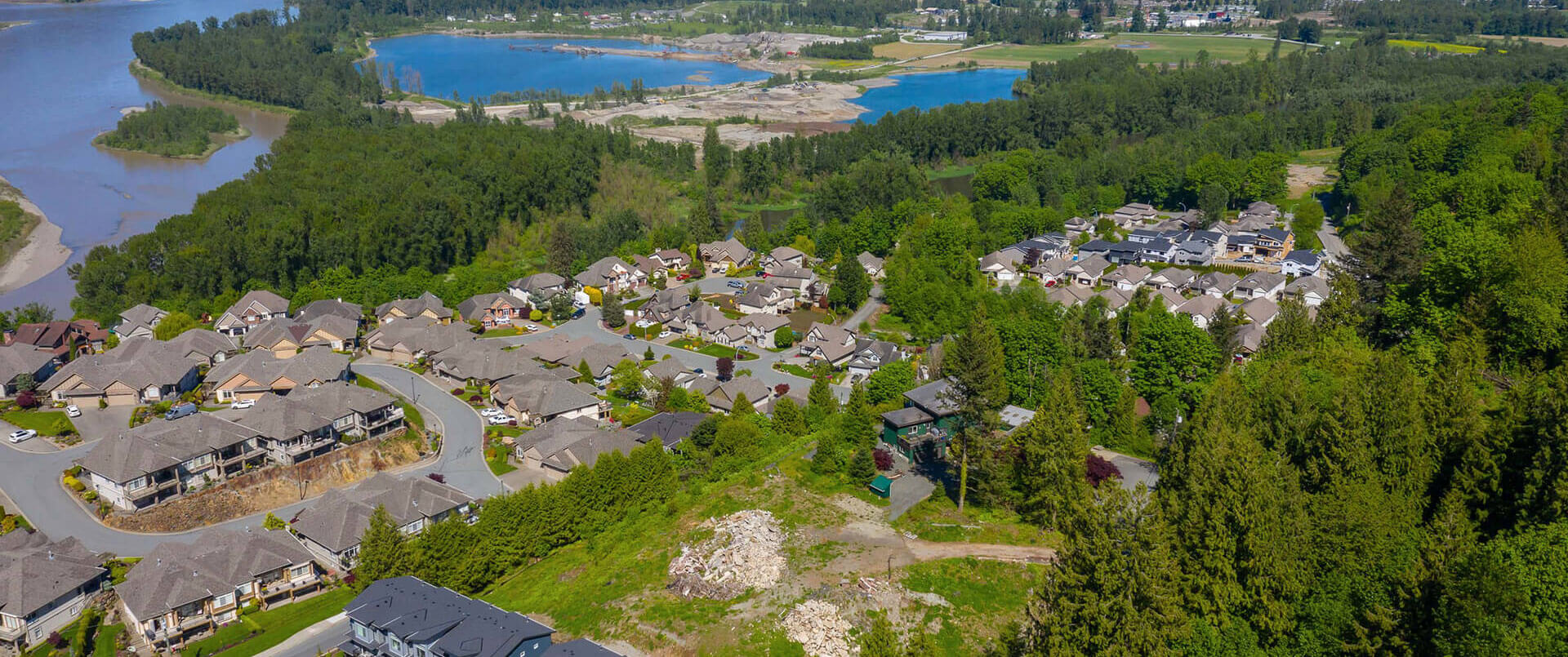 An empty plot of land next to single family homes in Chilliwack, BC