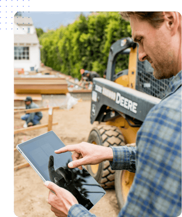 A field service manager exploring Hubstaff workforce productivity features on a tablet at a job site