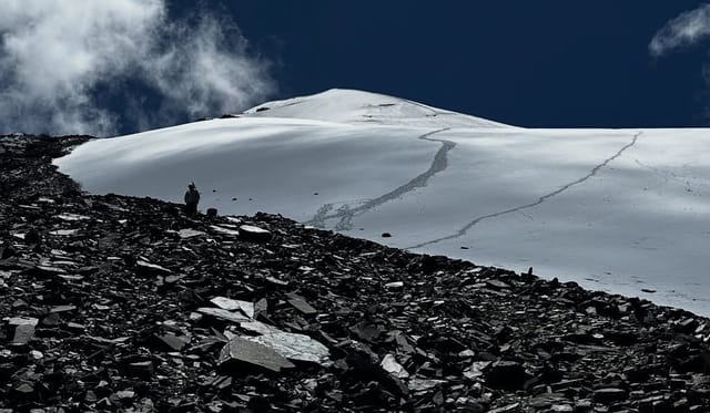 Snow-covered mountain ridge with climbing trail
