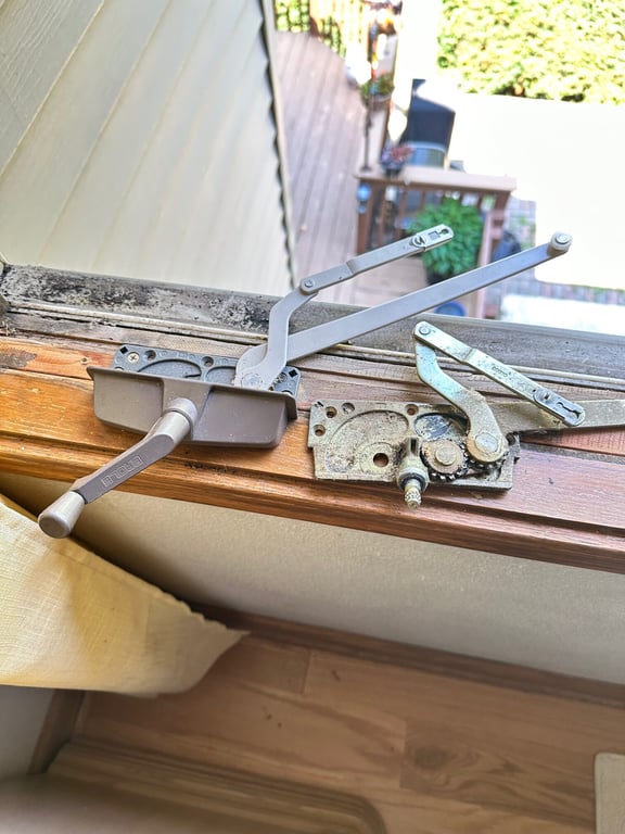 Window operator mechanism replacement showing old vs new Truth Entrygard hardware on wooden window frame in Charlotte home repair