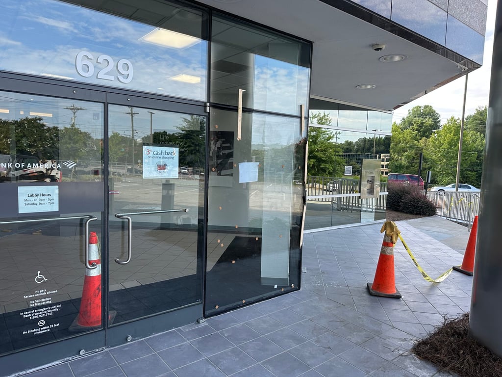 Bank of America branch 629 entrance with lobby hours display, handicap accessible entrance, and safety markers in Greensboro