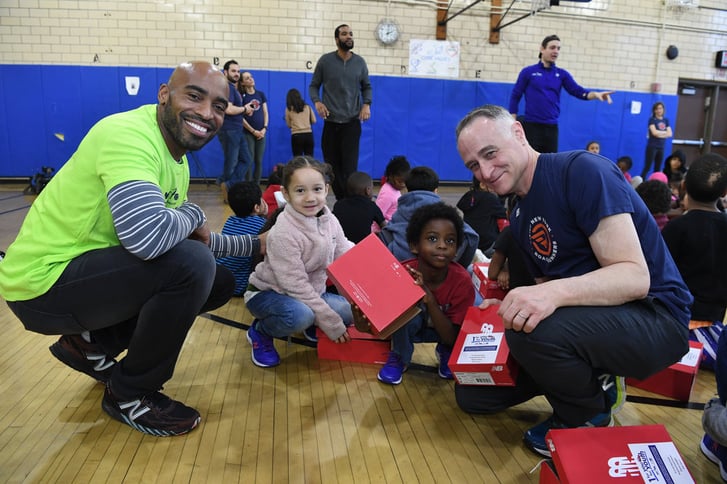 Tiki Barber and Michael Capiraso distribute free New Balance sneakers to students of PS 676K in Red Hook, Brooklyn.