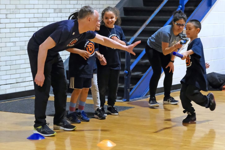 NYRR President and CEO Michael Capiraso running in a relay race with Rising New York Road Runners students at Jotham W. Wakeman No. 6 Elementary School in Jersey City