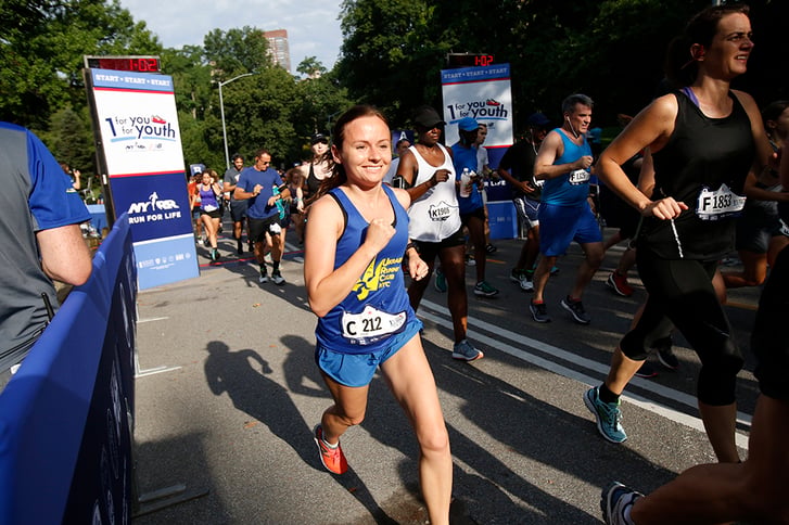 A woman starting the 1 For You 1 For Youth 5K in Central Park.