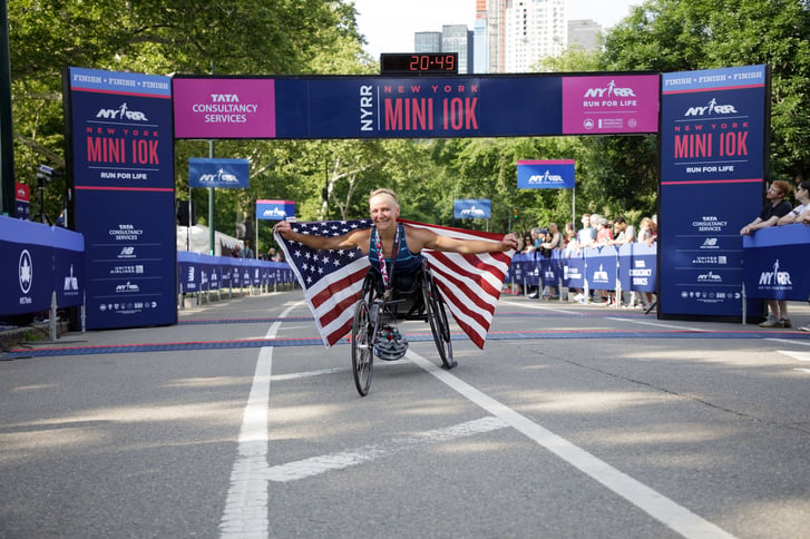 Susannah Scaroni after winning the 2018 New York Mini 10K holding the USA flag.