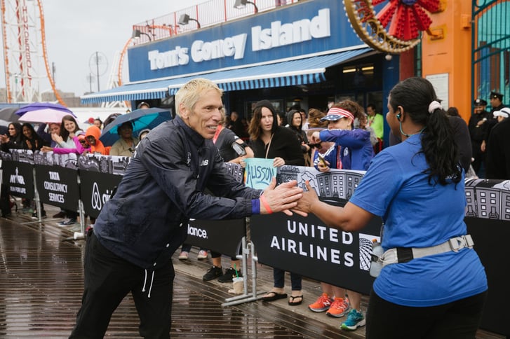 New York Road Runners Race Director Peter Ciaccia congratulating a Popular Brooklyn Half finisher