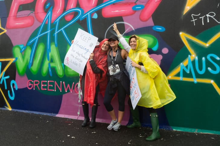 A runner after the Popular Brooklyn Half with two of her supporters and their signs
